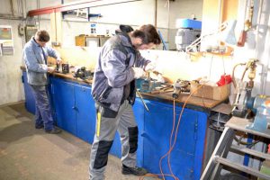 Die Ausbildung für Metallbauer*in - Fachrichtung Konstruktionstechnik findet bei Gawron im ersten Jahr in der Lehrwerkstatt statt. Hier feilt ein Auszubildender an einem Werkstück.