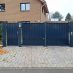 Drehflügeltor und Zauntür vor einem Einfamilienhaus mit einer blickdichten Füllung aus Stahlblech.