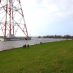 Sturmflut an der Elbe am 30.1.2022 mit Blick über den Deichfuß an der Hetlinger Schanze. Der gesamte Fuß vom Strommast ist von Wasser umgeben.