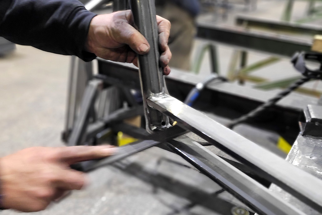 Mit einer Feile werden scharfe Kanten an einem Geländer aus Stahl entfernt. Das lernst du auch in der Ausbildung Metallbau 2024 bei Gawron.