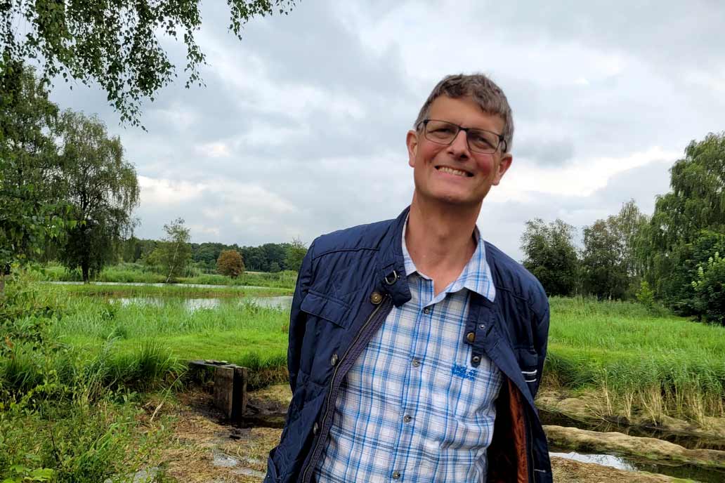 Volker Gawron grinst in die Kamera. er freut sich über den entspannten Ausflug mit den Kollegen zu Fischzucht Knutzen in Hohenlockstedt.