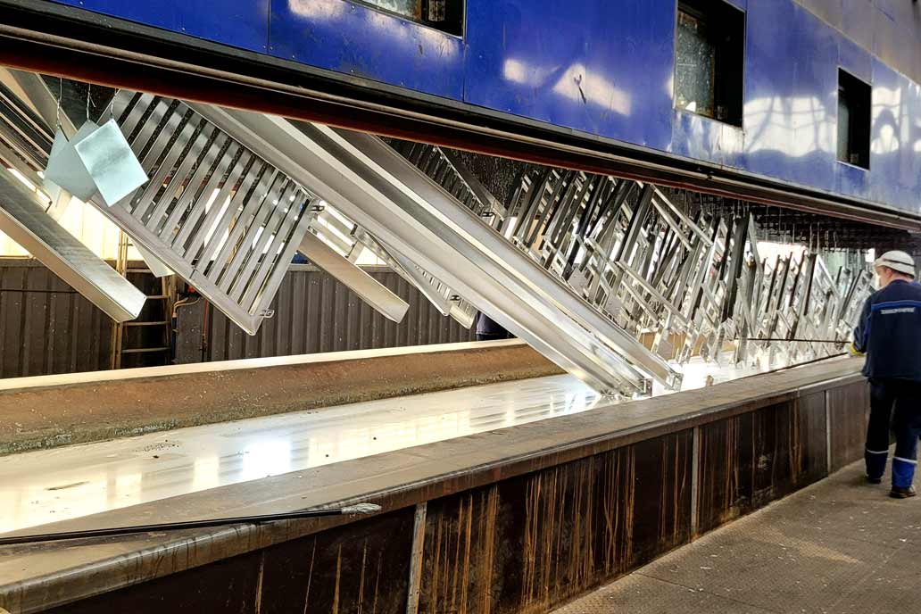 Die frisch verzinkten, glänzenden Stahlteile werden aus dem 450°C warmen Zinkbad gehoben.
