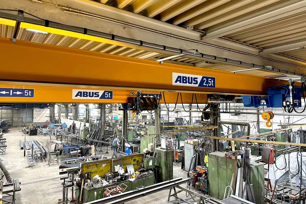 Blick in die Metallbauhalle von Gawron und Co mit den zwei neuen Brückenkranen. Vorne vor den Kranen sind die verzinkten Schienen der Energieketten zur Stromzuführung erkennbar. Rechts im Bild die Lauflkatze, die auf dem Haupträger fährt.