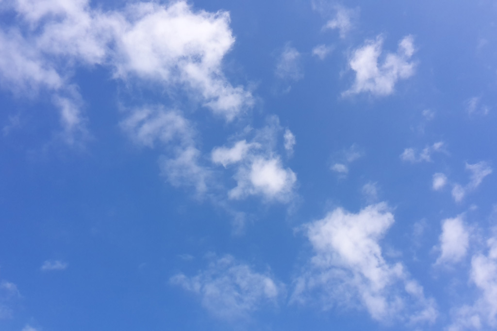 Strahlend blauer Himmel mit weißen Wolken.