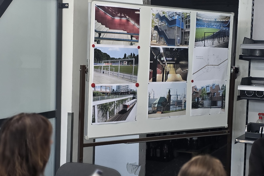 Betriebserkundung CVS 2026 Eine Magnetwand mit verschiedenen Fotos von Metallbauarbeiten. Rechts in der Mitte eine Zeichnung eines Geländers. Dasselbe Bauvorhaben findet sich in den Fotos oben links und in der Mitte: die beleuchteten Geländer am S-Bahnhof Reeperbahn.